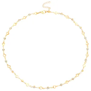 Detalle del collar de cadena de corazón dorado con eslabones huecos y cristales brillantes