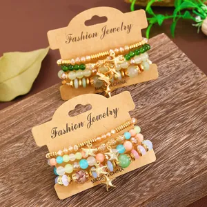 Bohemian multilayer beaded bracelets with starfish pendant on wooden background