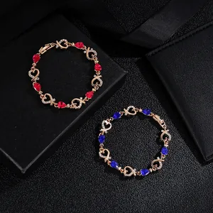 Macro shot of rose gold bracelets with red and blue heart gems in a black gift box
