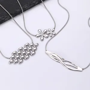 Vue détaillée de trois colliers en acier inoxydable argenté avec pendentifs gouttes de lave