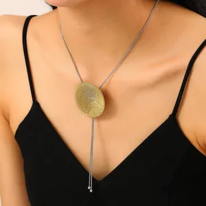 Détail du pendentif lave dorée avec ondulations concentriques sur chaîne en argent