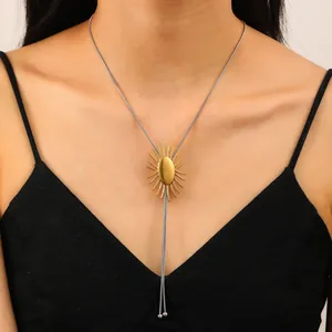 Détail du pendentif soleil doré réglable sur une chaîne serpent argentée sur modèle
