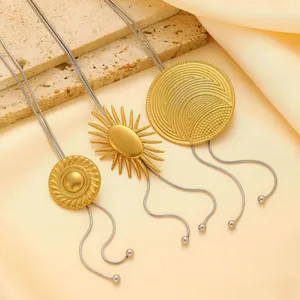 Détails de pendentifs lave dorés et chaînes serpent argentées sur pierre beige