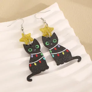 Macro shot of black acrylic cat earrings with glitter texture and gold star studs