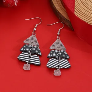 Detail of acrylic Christmas tree earrings with glitter and striped festive patterns