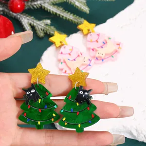 Detail of acrylic Christmas tree earrings with cute cat charms and glitter star studs