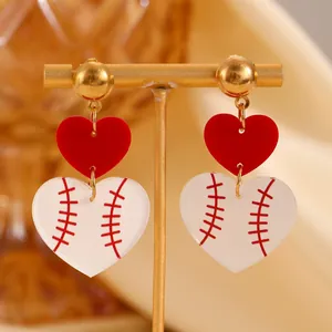 Fashionable double heart baseball earrings with red stitching on a gold jewelry stand