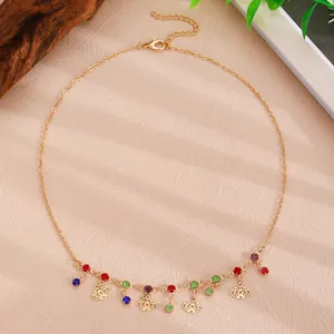 Close-up of golden necklace with colorful zircons and evil eye charms on textured background