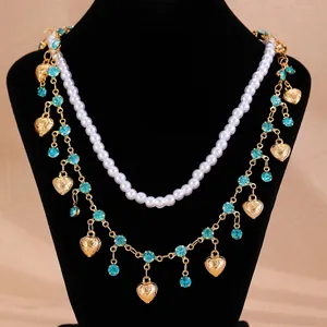 Double-layered gold necklace with white pearls, blue rhinestones and heart pendants