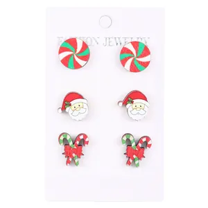 Three pairs of Christmas wooden stud earrings featuring Santa, candy canes, and sweets