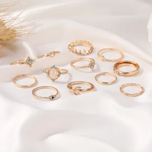 Detailset aus 12 goldfarbenen Boho-Ringen mit Stern- Mond- und Kronendesigns auf weißer Seide