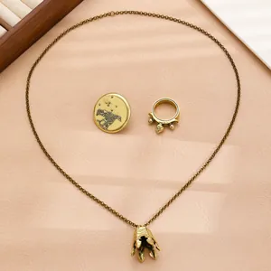 Macro view of vintage bronze jewelry set featuring bell pendant, ring and bird badge