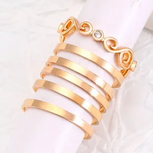 Detail von 6-teiligem Goldring-Set mit Wellendesign und einem funkelnden Zirkonstein