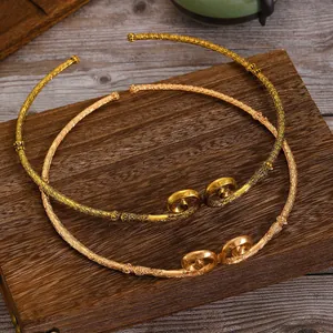Close-up of golden Sun Wukong fillet necklaces with traditional Chinese cloud relief patterns