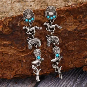 Detailaufnahme von Western-Cowboy-Ohrringen mit Türkisperlen auf rustikalem Holzgrund