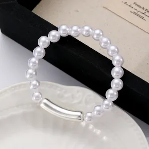 Elegant faux pearl bracelet with a silver bamboo-style metal tube on a jewelry tray