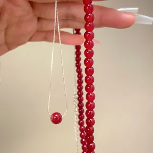 Detalle de un colgante de ágata roja pulida en una fina cadena de plata pura