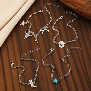 Détail de breloques cowboy argentées avec tête de taureau, cactus et pendentif turquoise