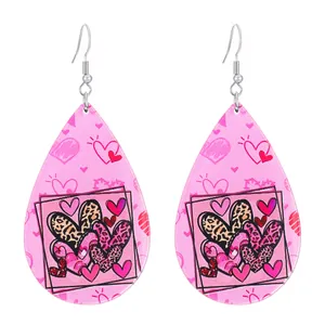 Vue détaillée des boucles d'oreilles goutte en acrylique avec motifs cœurs roses et léopard