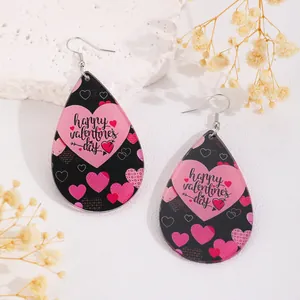Détail de boucles d'oreilles en acrylique en forme de goutte avec motif de cœur
