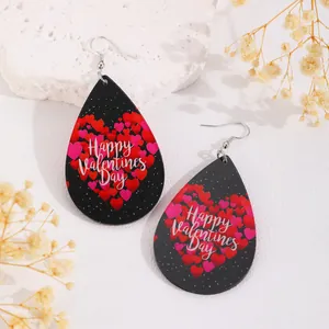 Détail de boucles d'oreilles gouttes avec cœurs rouges et texte Happy Valentines Day