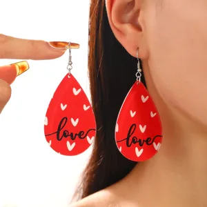 Boucles d'oreilles en forme de goutte rouges avec cœurs blancs et texte love noir