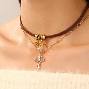 Close-up of double-layered star and cross pendant necklace with brown leather choker strap