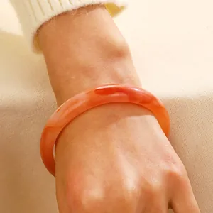 Orange marble textured resin bangle with irregular pattern in a punk chunky style