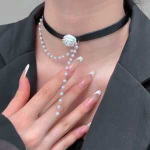 Detail of black leather choker with white 3D rose and layered faux pearl tassel chains