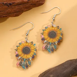 Detail view of sunflower earrings made of printed acrylic with rustic wood background