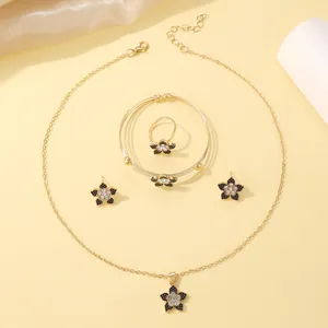 Macro detail of gold flower jewelry set featuring black and white zircon stone inlay