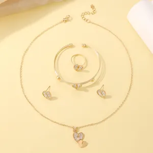 Detailed close-up of luxury gold heart jewelry set with crystal inlay on silk fabric