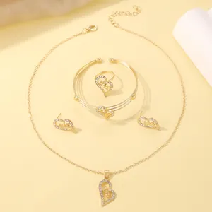 Detailed view of gold heart jewelry set with LOVE engraving and shimmering crystals