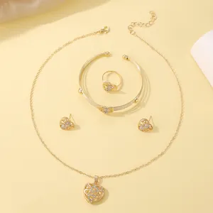 Detailed set including heart pendant necklace, open bangle, ring and stud earrings in gold finish
