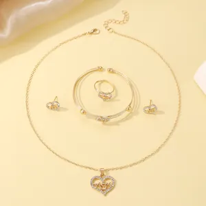 Detailed macro view of gold heart jewelry set featuring MOM engraving and white crystals