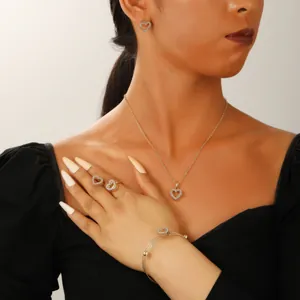 Detailed view of luxury gold heart jewelry set including necklace and rings on model