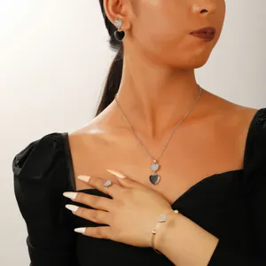 Close-up of heart-shaped zircon necklace and earrings set worn on a model