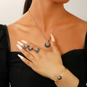 Model wearing gold-plated jewelry set with white crystals and black circular accents