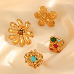 Detail view of four vintage bohemian gold rings with turquoise and pearl embellishments