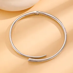 Detail of minimalist silver open cuff bracelet showing hidden spring hinge and smooth metal