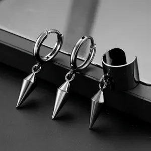 Macro shot of punk black spiked earrings and ear cuff set with conical metal pendants