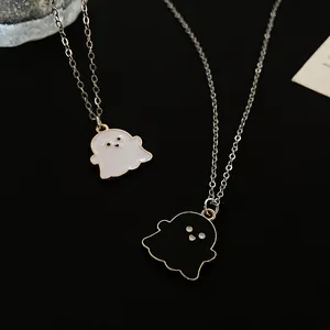 Detailed view of the cute black and white enamel ghost pendants with gold-plated edges