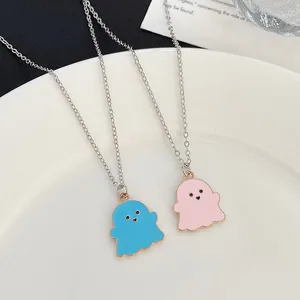 Close-up of cute blue and pink ghost necklaces with heart eyes in a white dish