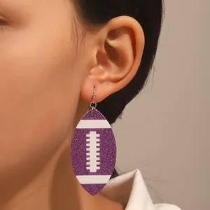 Glitter purple American football earrings worn by female model with silver hooks