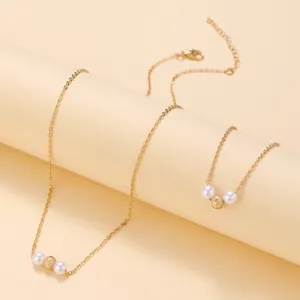 Elegante set di collana e bracciale dorati con perle bianche e perline d'oro testurizzate