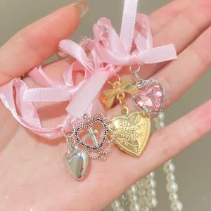 Double-layer crystal pearl necklace with pink ribbon and multi-heart pendants on hand