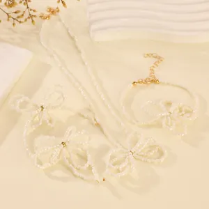 Detail view of handmade beaded jewelry set with flower charms on a beige stone base
