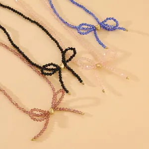 Detail of faceted beaded necklaces with central bow designs and golden heart accents