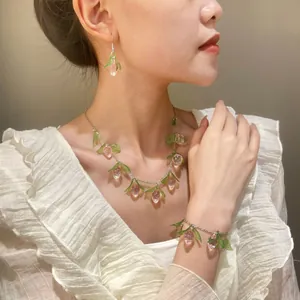 Detalle del colgante de fresa rosa y el juego de joyas a juego lucido por la modelo