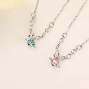 Detail of heart planet and butterfly pendants with blue and pink stones on silver chains